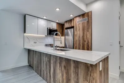 a kitchen with a sink and wooden cabinets at Luxury 2BR Walk to Everything Downtown in Vancouver