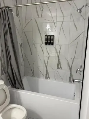 a bathroom with a white tub and a toilet at Cozy 1 Bedroom suite close to west edmonton mall in Edmonton