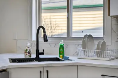 a kitchen sink with dishes in a window at Affordable & Cozy 3-bedroom, Minutes to City Core in Calgary