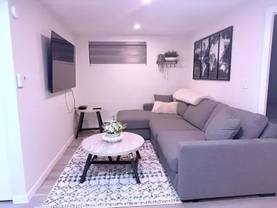 a living room with a couch and a table at Cozy Haven 2 in Bélanger