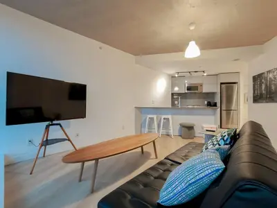 a living room with a couch and a table at Gastown Unbeatable View 1 Bedroom High Floor Condo Rooftop View of Downtown in Vancouver