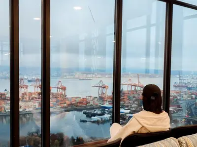 a woman sitting on a bench looking out the window of a ship at Gastown Unbeatable View 1 Bedroom High Floor Condo Rooftop View of Downtown in Vancouver