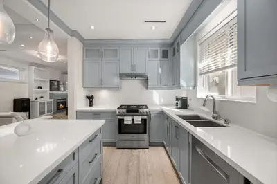 a kitchen with white cabinets and a stove top oven at Your Next Stay Spacious Bright & Sophisticated in Vancouver