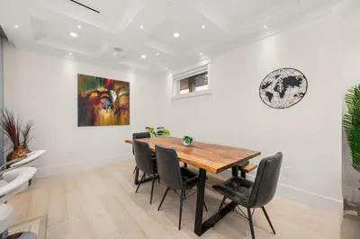a dining room with a wooden table and black chairs at Your Next Stay Spacious Bright & Sophisticated in Vancouver
