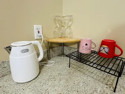 a counter with a table with vases and a coffee maker at Moon rooms in Vancouver