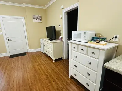 a kitchen with a white dresser with a microwave on it at Moon rooms in Vancouver