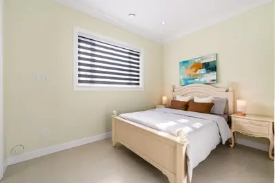 a white bedroom with a bed and a window at Modern Vancouver Private Room-15 Mins to Downtown in Vancouver