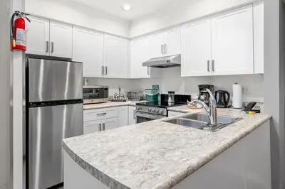 a kitchen with white cabinets and a stainless steel refrigerator at Ski-in and Out Lake Placid Lodge in Whistler