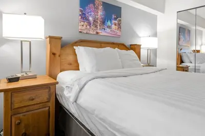 a bedroom with a bed and two lamps on a nightstand at Ski-in and Out Lake Placid Lodge in Whistler