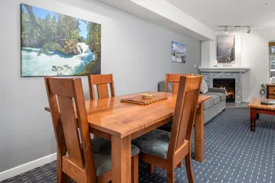 a dining room with a table and a fireplace at Ski-in and Out Lake Placid Lodge in Whistler