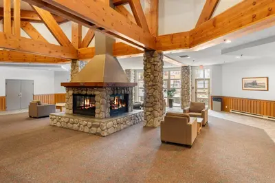 a large living room with a stone fireplace at Ski-in and Out Lake Placid Lodge in Whistler