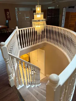 a white spiral staircase with a chandelier in a house at Surrey-Delta Urban Stay - Walk to Transit & Shopping in Surrey
