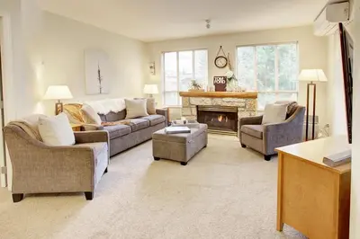 a living room with two couches and a fireplace at Heart of Whistler Village, Mountain Views, Pool & Hot Tub in Whistler