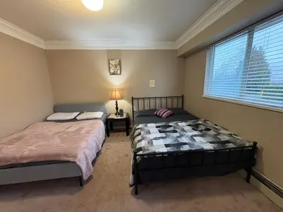 a bedroom with two beds and a window at Nordel Way Guest House - Walk to Transit & Shopping - 20 Min to YVR in Surrey