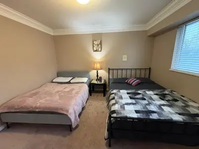 a bedroom with two beds and a window at Nordel Way Guest House - Walk to Transit & Shopping - 20 Min to YVR in Surrey