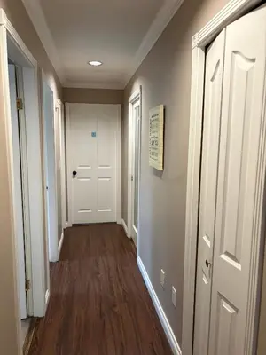 a hallway with a white door and wooden floors at Nordel Way Guest House - Walk to Transit & Shopping - 20 Min to YVR in Surrey