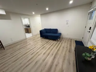 a living room with a blue chair and a wooden floor at Downtown Vancouver Cozy Room - Near SkyTrain, BC Place & Free Parking in Vancouver