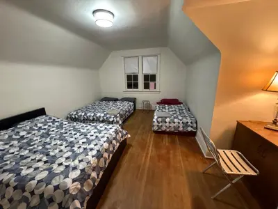 a room with three beds and a window at Vancouver Large Room for 5 - Near YVR Airport, Transit & Free Parking in Vancouver