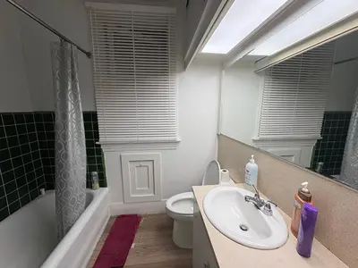 a bathroom with a sink and a toilet and a mirror at Vancouver Large Room for 5 - Near YVR Airport, Transit & Free Parking in Vancouver
