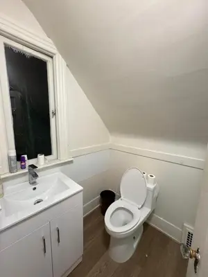 a white bathroom with a toilet and a sink at Vancouver Large Room for 5 - Near YVR Airport, Transit & Free Parking in Vancouver
