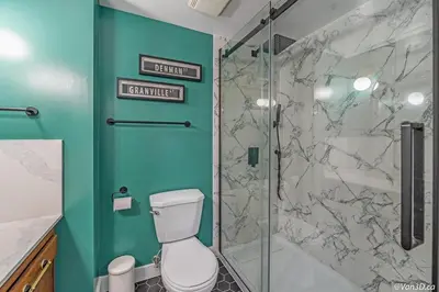 a bathroom with a toilet and a glass shower at Beautiful Downtown Studio with Parking in Vancouver