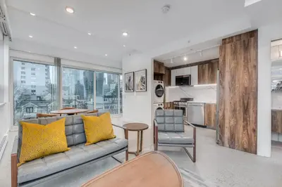 a living room with a couch and chairs and a kitchen at Upscale 1BR2BA Walk Everywhere in Vancouver