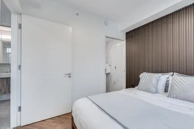 a bedroom with a large bed with a wooden headboard at Upscale 1BR2BA Walk Everywhere in Vancouver