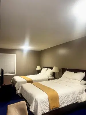 a hotel room with two beds with white sheets at Rainbow INN in Terrace