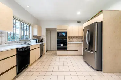 a kitchen with a stainless steel refrigerator and cabinets at Cozy & Modern Room near Langara & Downtown in Vancouver