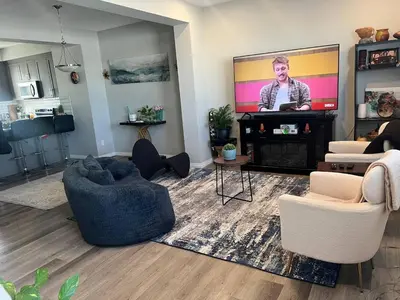 a living room with a flat screen tv and chairs at Spacious Private Room with TV, WiFi and Fridge in Edmonton