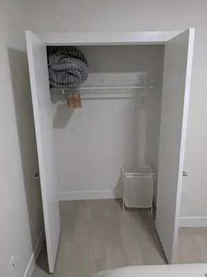 an empty room with a white wall and a closet at Greystone Retreat - Walk to River & Downtown in Cochrane