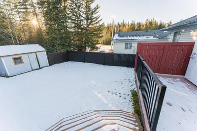 a backyard covered in snow with a fence at Bright 3BR Upper Suit, 23 min to Jasper NP in Hinton