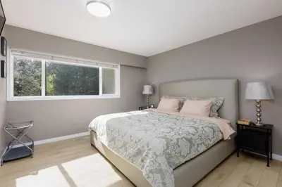 a bedroom with a bed with pink pillows and a window at The Forest Pedal House in Squamish