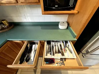 a kitchen counter with a drawer full of utensils at The Forest Pedal House in Squamish