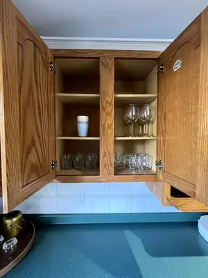 a kitchen with wooden cabinets with bowls and glasses at The Forest Pedal House in Squamish