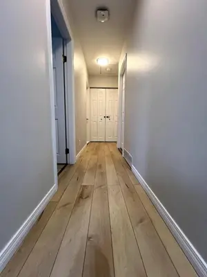 an empty hallway with white walls and wood floors at The Forest Pedal House in Squamish