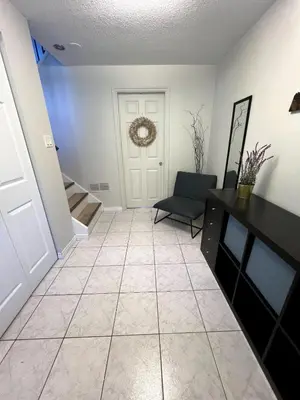 a hallway with a black chair and a door at The Forest Pedal House in Squamish