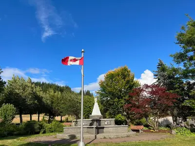 a flag flying over a monument in a park at Chalet Inn in Kitimat