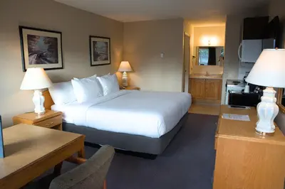 a hotel room with a bed and a kitchen at Chalet Inn in Kitimat