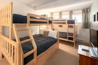 a room with two bunk beds and a desk at Panorama Mountain Resort - Horsethief Lodge with Fairmont Creek in Panorama