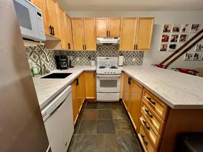 a kitchen with wooden cabinets and a white stove top oven at Panorama Mountain Resort - Horsethief Lodge with Fairmont Creek in Panorama