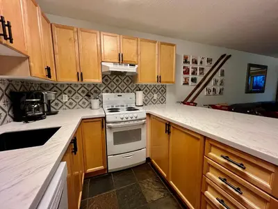 a kitchen with wooden cabinets and a white stove top oven at Panorama Mountain Resort - Horsethief Lodge with Fairmont Creek in Panorama