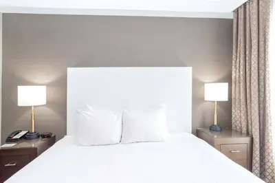 a hotel room with a large bed with two lamps at Sandman Hotel Abbotsford Airport in Abbotsford