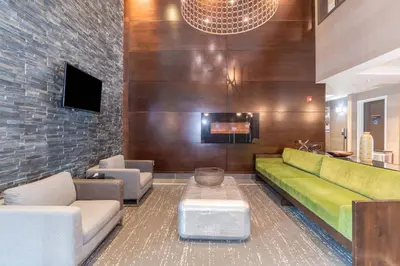 a living room with a green couch and chairs at Sandman Hotel Abbotsford Airport in Abbotsford