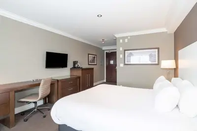 a hotel room with a bed and a desk and a television at Sandman Hotel Abbotsford Airport in Abbotsford