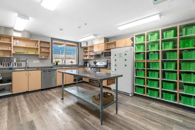 a large kitchen with a table and a refrigerator at Squamish Adventure Inn in Squamish
