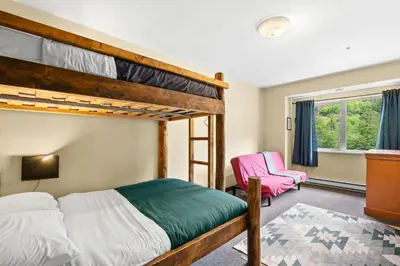 a bedroom with two bunk beds and a chair at Squamish Adventure Inn in Squamish