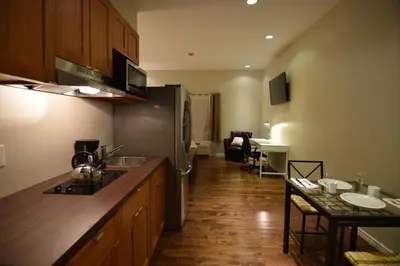 a kitchen with a refrigerator and a table in it at The Lion Inn & Suites in Chetwynd