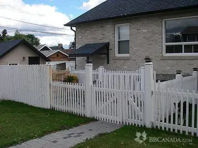 a white picket fence in front of a house at The White Brick Inn in Jasper