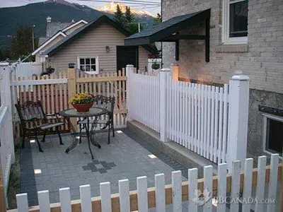 a patio with a table and a white fence at The White Brick Inn in Jasper